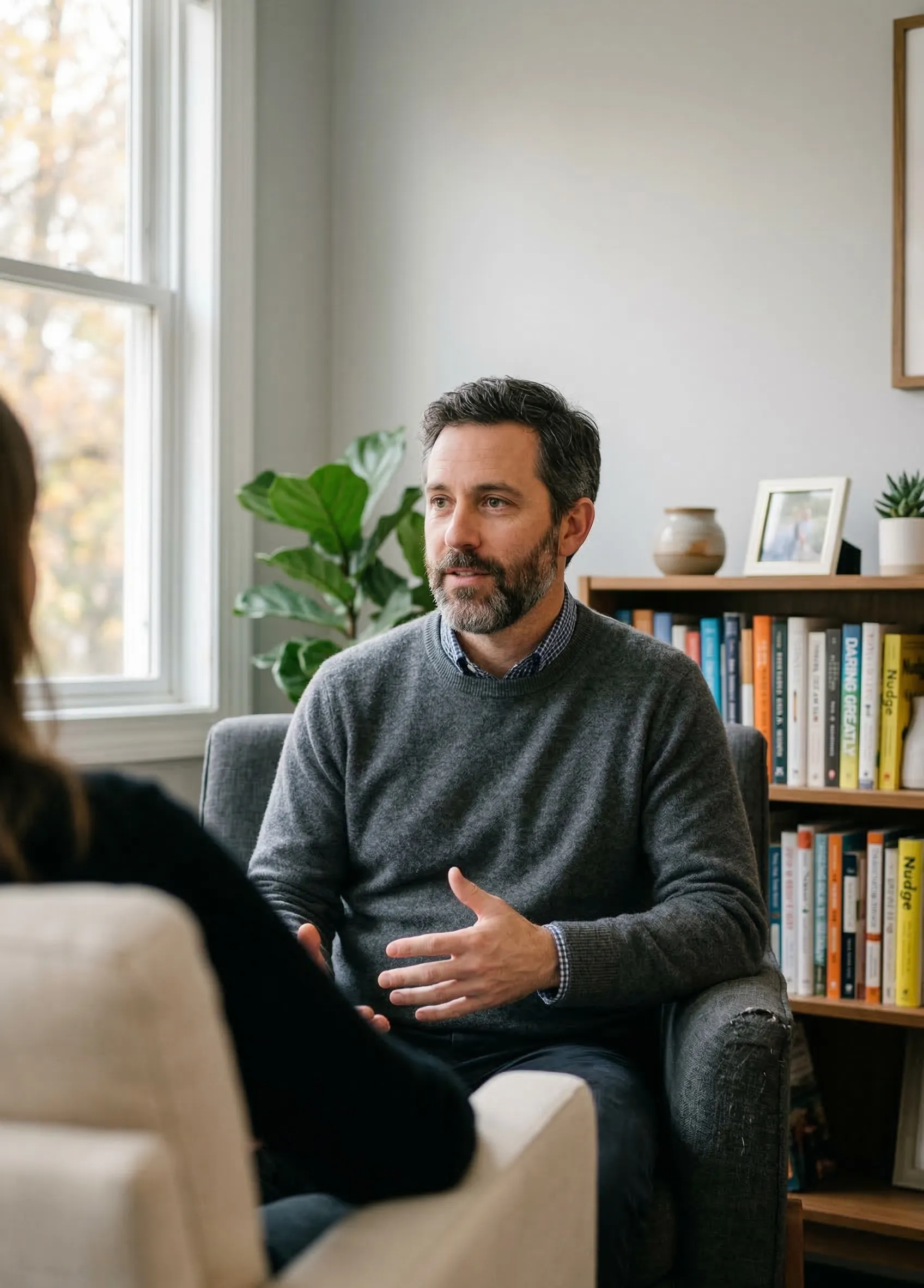 Psychologist speaking with a client during a therapy session in a consulting room